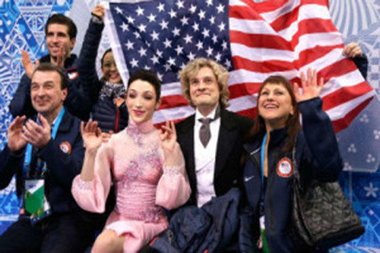 Meryl Davis and Charlie White await with coaches for their judgement in the Team Event
