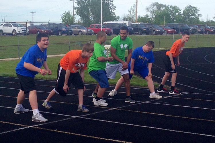 Competitors from all three schools line up at the starting line to run the 100 meter dash.