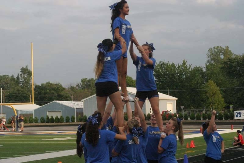 In this photo, the cheer squad is performing one of the newer stunts that is also supported by the teams male cheerleader, Senior Jacob Sparkman. 