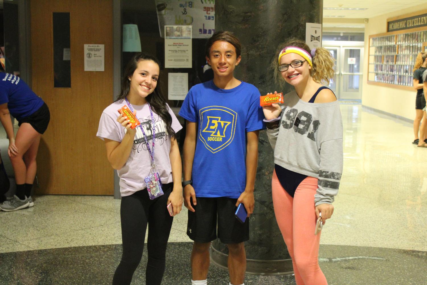 Sophomores Jenna Zabona, Ian Schowe and Allyson Diehl stand in pride holding their winning prizes of Reeses Peanut Butter Cups. 